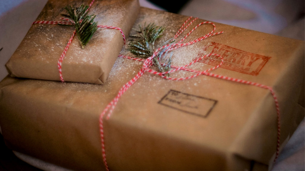 Two gifts wrapped with reused brown paper and ribbon