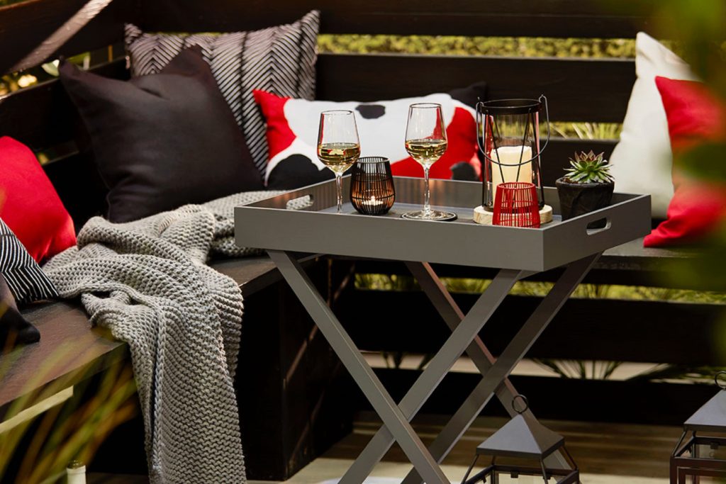 wine on gray tray with pillows and blanket