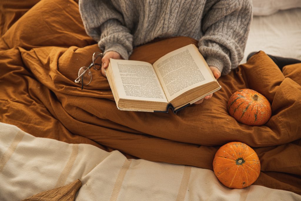 Woman reading a book in a cozy bed